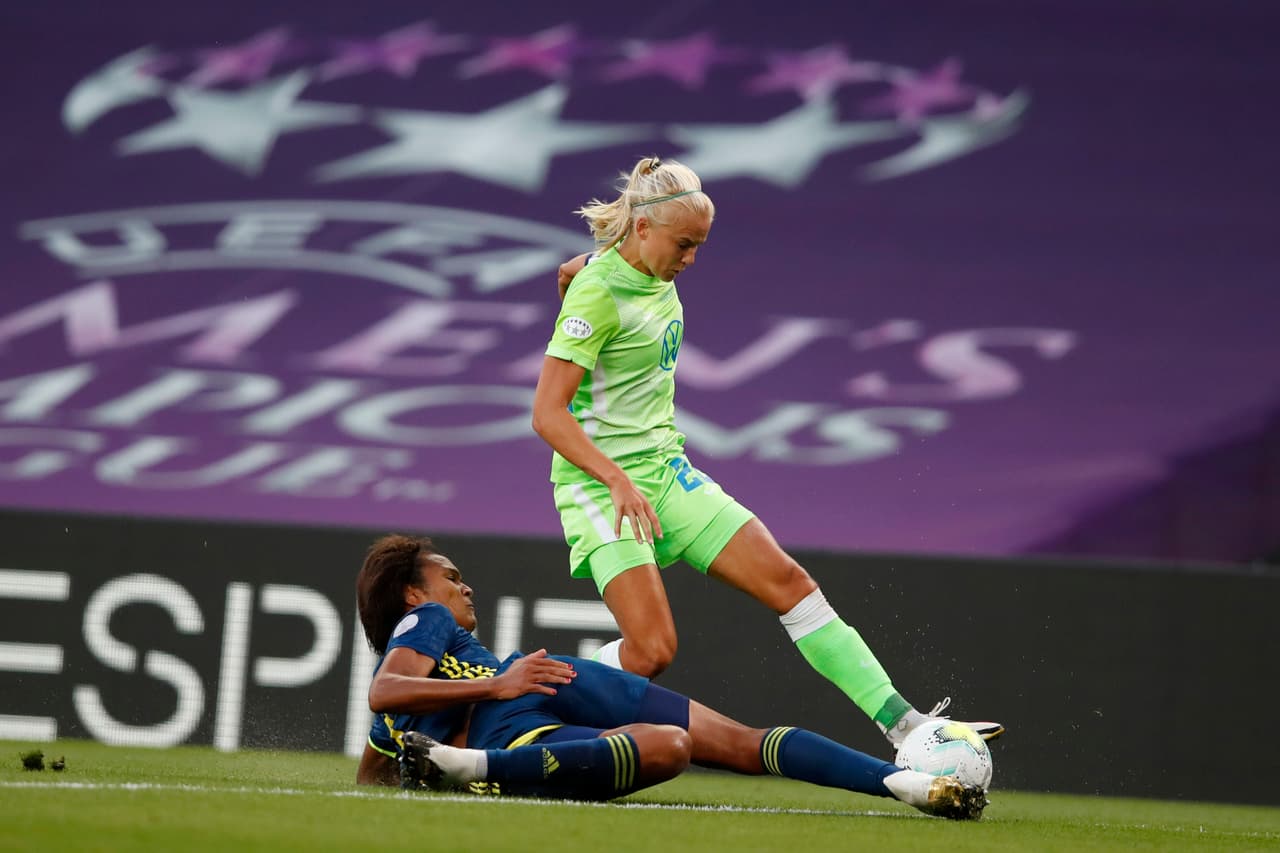 Wendie Renard busca quitarle el esférico a Pernille Harder.