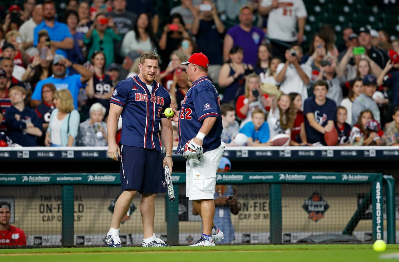 J.J. Watt en plática con el ex jugador de Ligas Mayores Roger Clemens, quien fue uno de los entrenadores durante el J.J. Watt Charity Classic softball game en Houston.