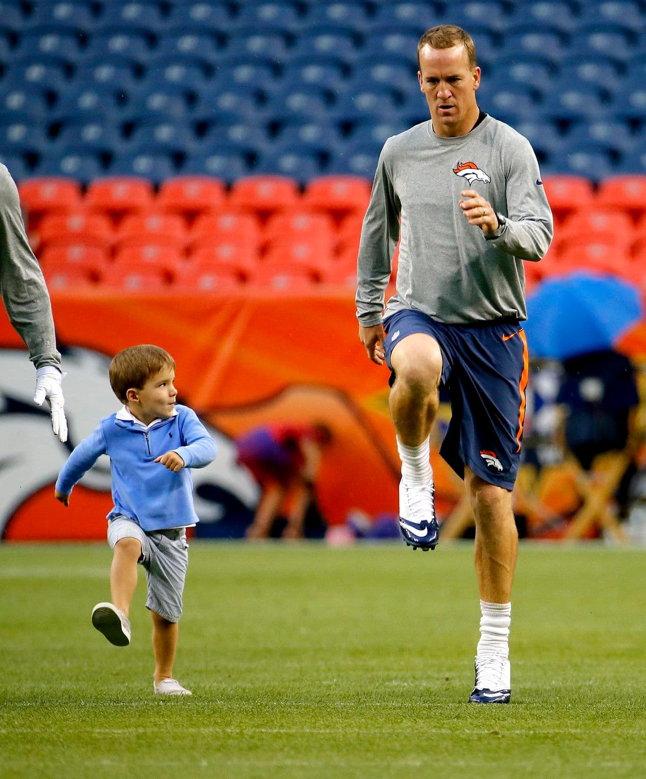 #8. La estrella de Denver, el QB Peyton Manning, hacienda el calentamiento con su pequeño hijo, Marshall, antes de entrar en acción ante los Cardinals