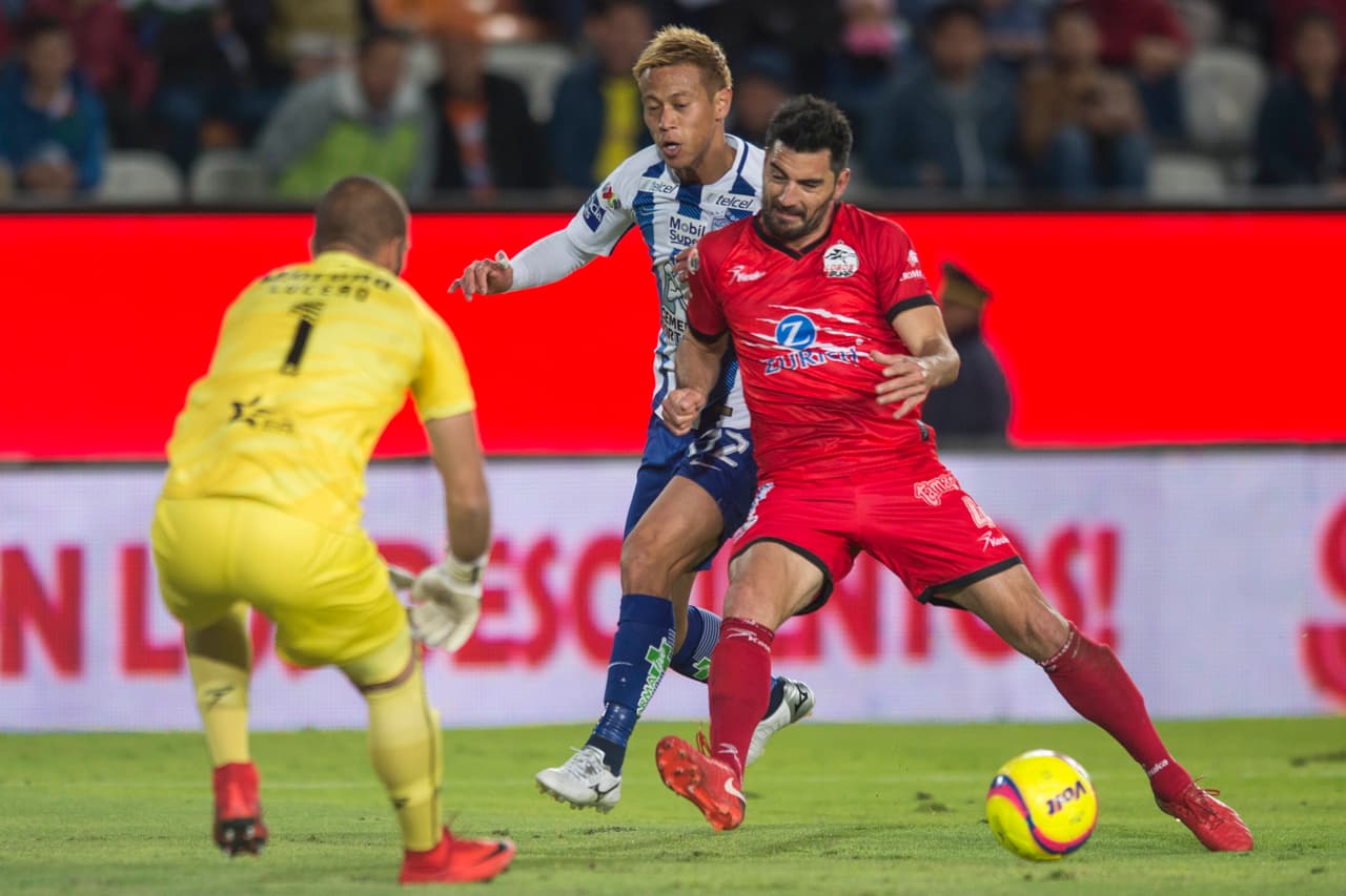 Facundo Erpen (rojo) peleando el balón con Keisuke Honda.