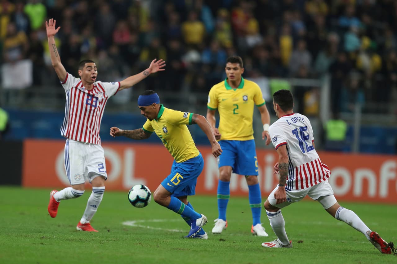 Allan, con un vendaje en la cabeza, tratando de pasar entre la dura defensa guaraní, en un arranque de partido bien complicado para los brasileños.