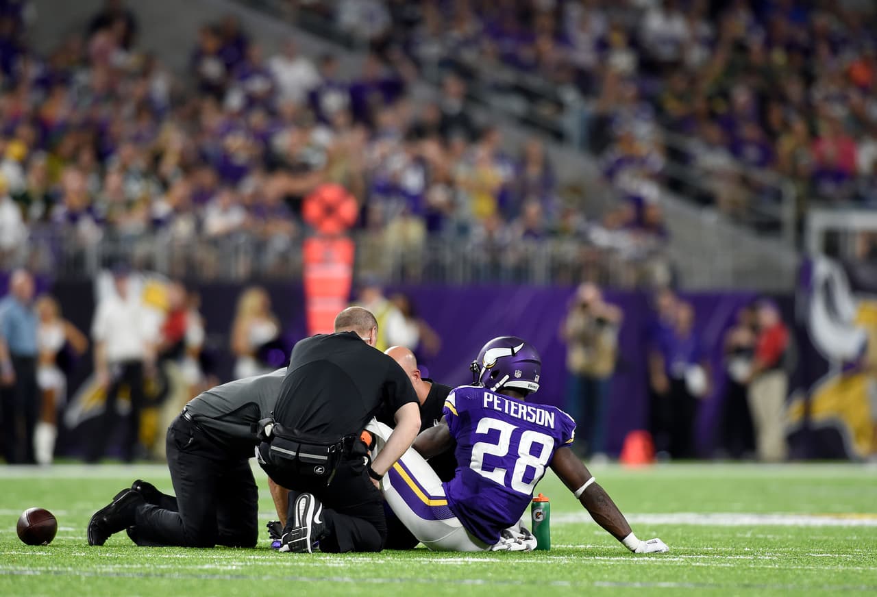 MINNEAPOLIS, MN - SEPTEMBER 18: Adrian Peterson #28 of the Minnesota Vikings sits on the field as trainers tended to his knee in the third quarter of the game against the Green Bay Packers on September 18, 2016 at US Bank Stadium in Minneapolis, Minnesota. Peterson was carried to the sidelines and later went to the locker room. (Photo by Hannah Foslien/Getty Images)