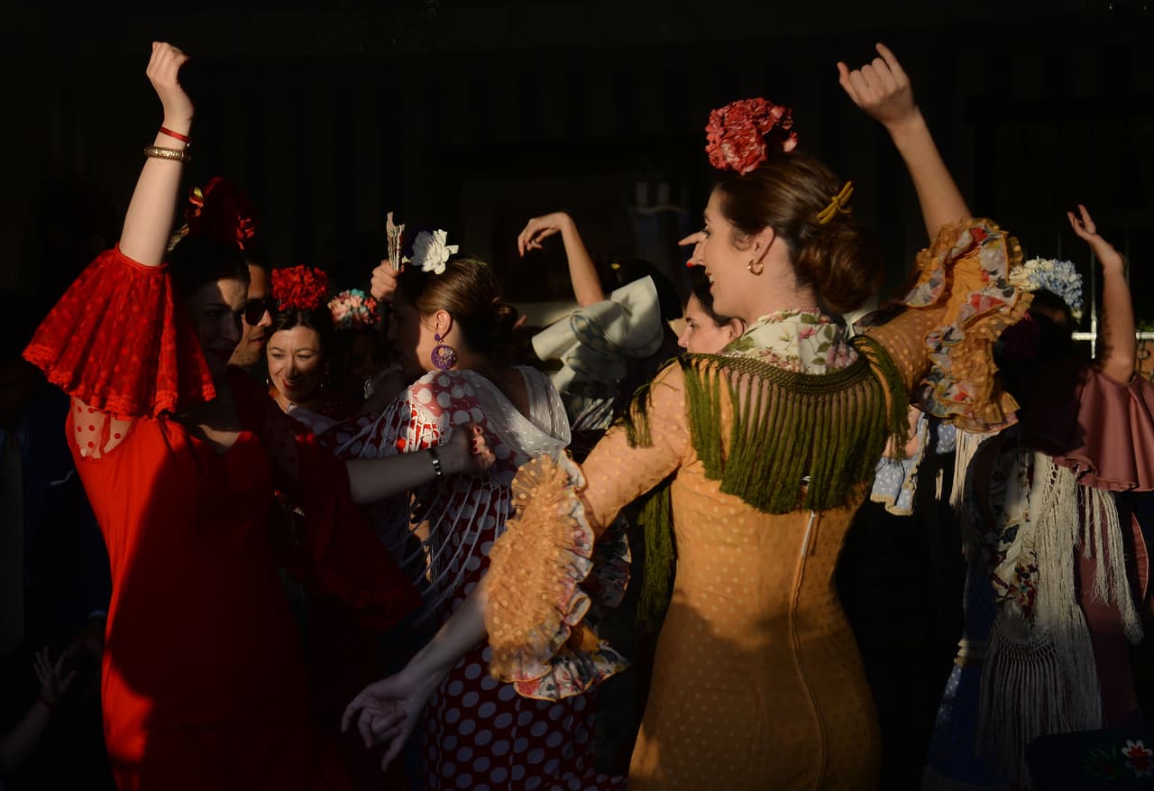 Las mujeres con vestidos de flamenca tradicionales bailan "sevillanas" en una "caseta". La feria se remonta a 1847, cuando originalmente se organizó como una feria de ganado. Pero se ha convertido en una semana de baile flamenco, música y corridas de toros.