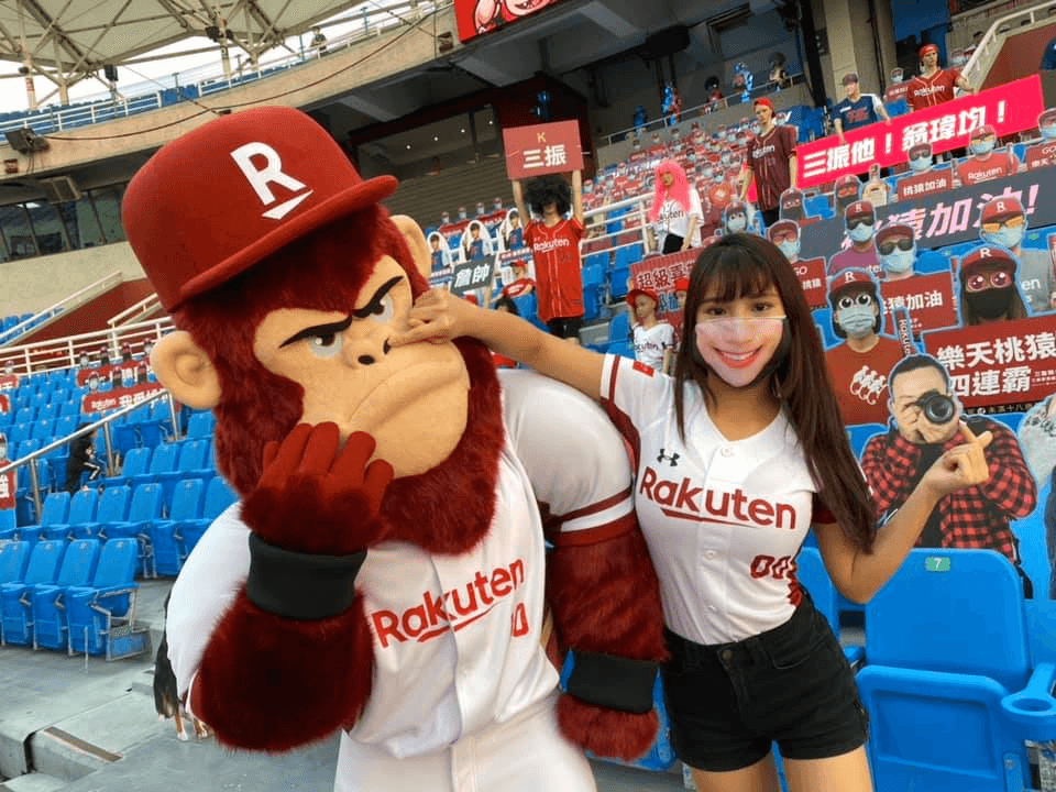 La mascota de los Rakuten Monkeys y una porrista haciendo bromas.