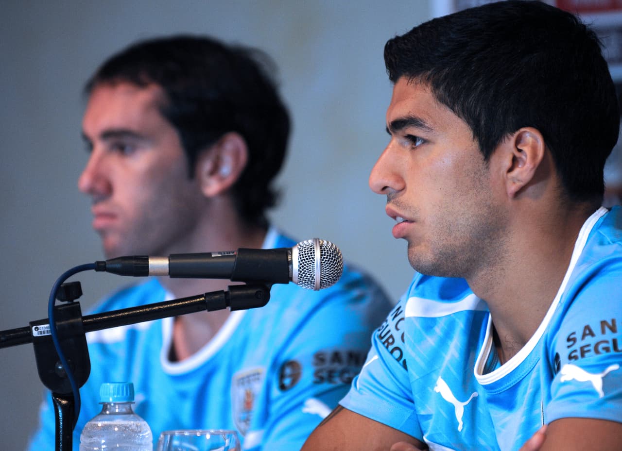 Uruguay's forward Luis Suarez (R) and defender Diego Godin are seen during a press conference in Salvador on June 28, 2013. The upcoming WC 2014 Confederation Cup third place tournament footbal match between Uruguay and Italy will take place on June 30 at the Arena Fonte Nova stadium in Salvador, Brazil. AFP PHOTO / DANIEL GARCIA. (Photo credit should read DANIEL GARCIA/AFP/Getty Images)