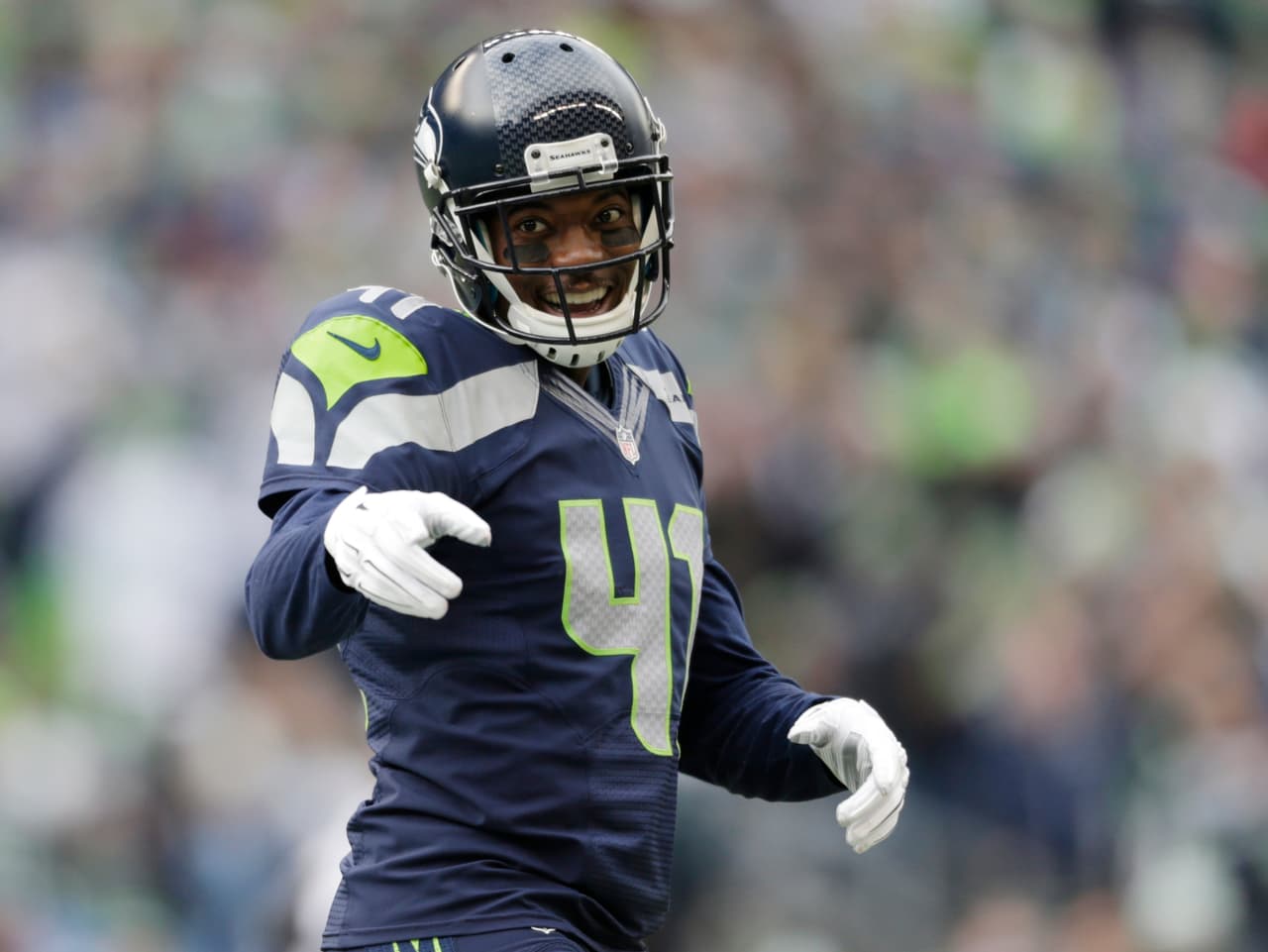 Seattle Seahawks' Byron Maxwell smiles and points to other players between plays against the St. Louis Rams in the first half of an NFL football game, Sunday, Dec. 28, 2014, in Seattle. (AP Photo/John Froschauer)