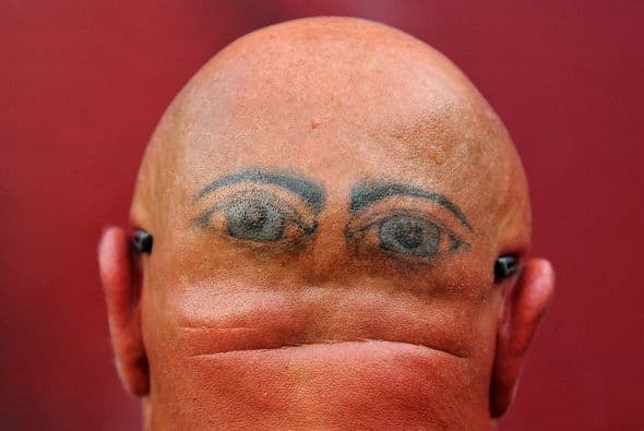 Larry Mooney posa para un retrato que muestra sus ojos tatuados en la parte posterior de su cabeza durante un partido de pretemporada de la NFL.