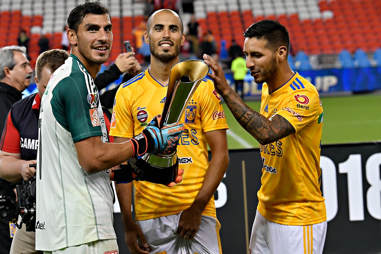 Nahuel Guzmán, Guido Pizarro y Lucas Zelarayán posando y sonriendo para la foto con el trofeo.