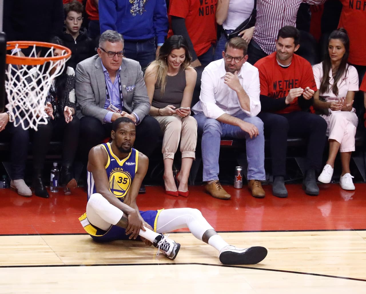 Luego de las críticas que se arrojaron hacia los aficionados de los Toronto Raptors, por iniciamente festejar la lesión sufrida por el delantero de los Golden State Warriors, Kevin Durant, quien en la imagen se aferra a su pantorrilla tras lesionarse el tobillo y que a la postre se dijo fue rotura del talón de Aquiles que le impedirá incluso jugar toda la temporada 2019-20 de la NBA.
