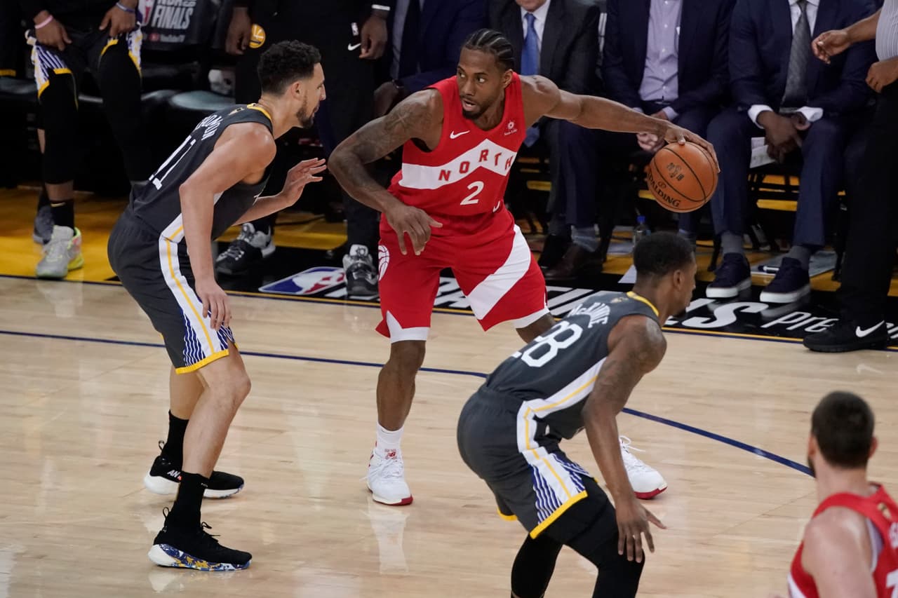 El astro de los Toronto Raptors forward Kawhi Leonard (2) en problemas ante la dura defensa que le estaba aplicando Golden State. Apenas al punto medio del periodo sumó su tercera canasta.