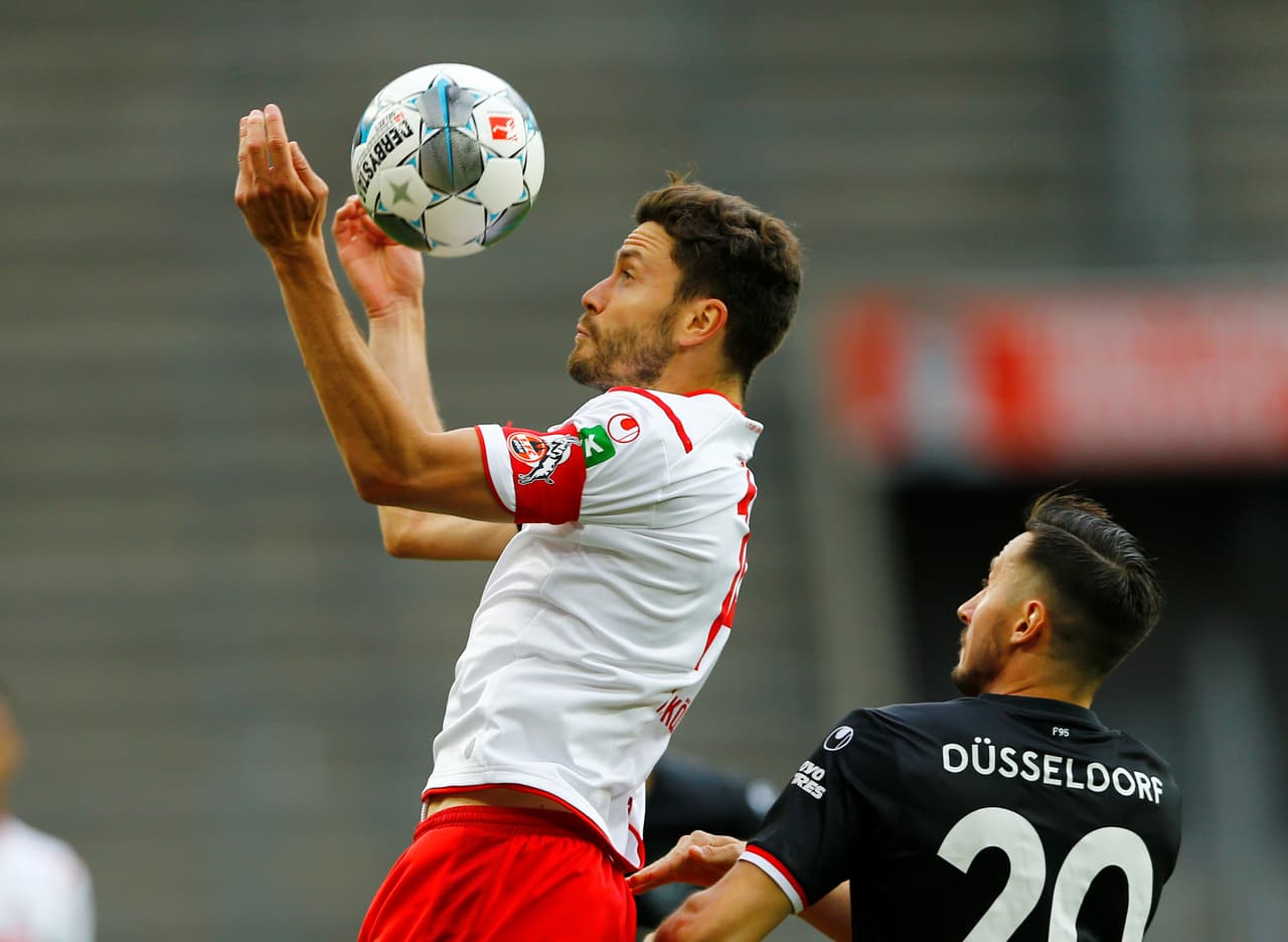 Jonas Hector gana el duelo aéreo a Steven Skrzybski y se queda con el esférico.