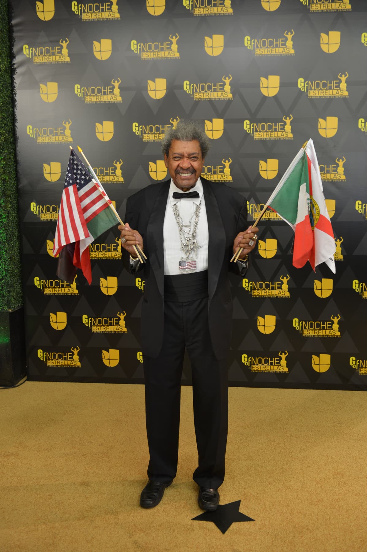 El promotor leyenda de boxeo Don King llegó a la alfombra lleno de banderitas.