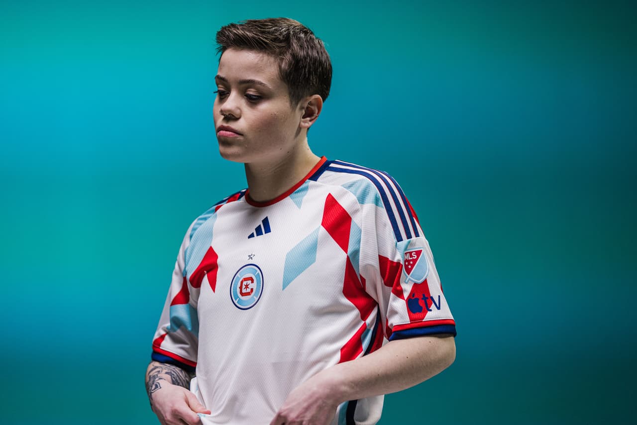 El fondo blanco de la playera está decorado por rombos rojos y azules.