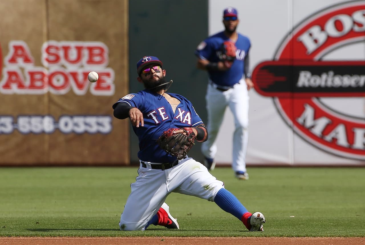 El segunda base de los Texas Rangers Rougned Odor,se posiciona para sacar un out en la primera base con rodilla en tierra, una postura muy eleganteen el partido contra los San Francisco Giants.