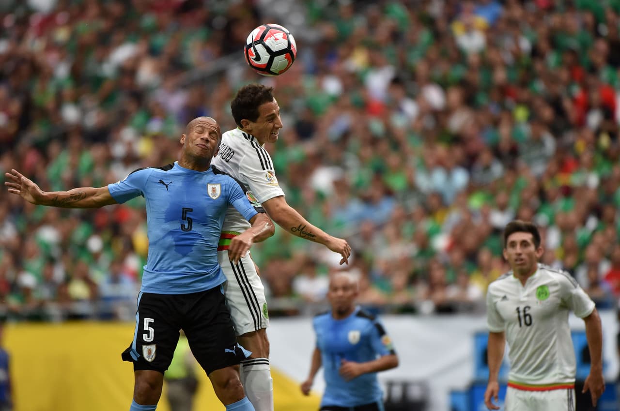 Carlos Sanchez de Uruguay y Andres Guardado de Mexico, saltan por el balón.