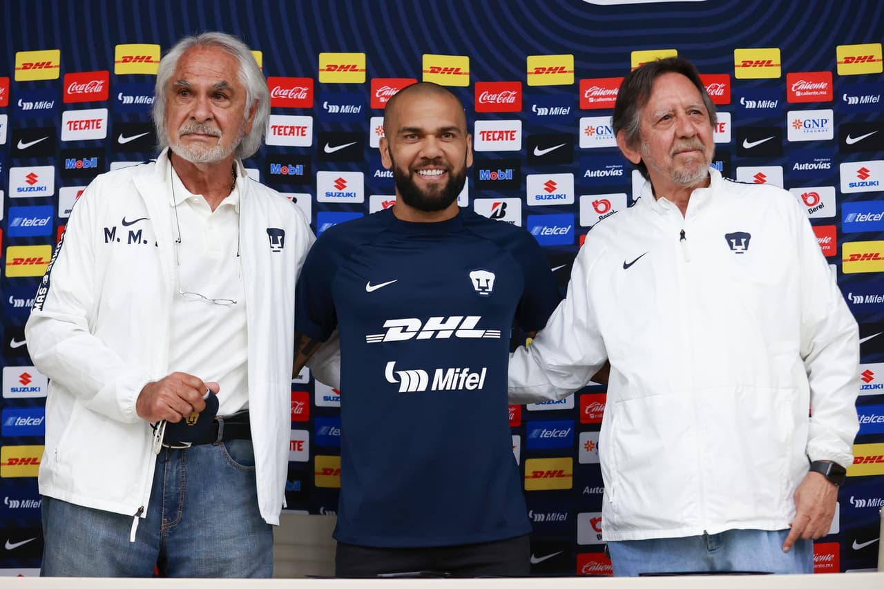 Dani Alves firmando su contrato de un año con Pumas junto al ingeniero Leopoldo Silva, presidente de la junta directiva, y Miguel Mejía Barón, vicepresidente deportivo.