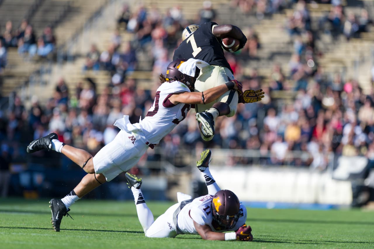 Purdue running back D.J. Knox (1) is knocked out of the air by Minnesota linebacker Jack Lynn (50) as he leaps over the tackling efforts of Minnesota defensive back Antonio Johnson (11) during the first half of an NCAA college football game, Saturday, Oct. 10, 2015, in West Lafayette, Ind. (AP Photo/Doug McSchooler)