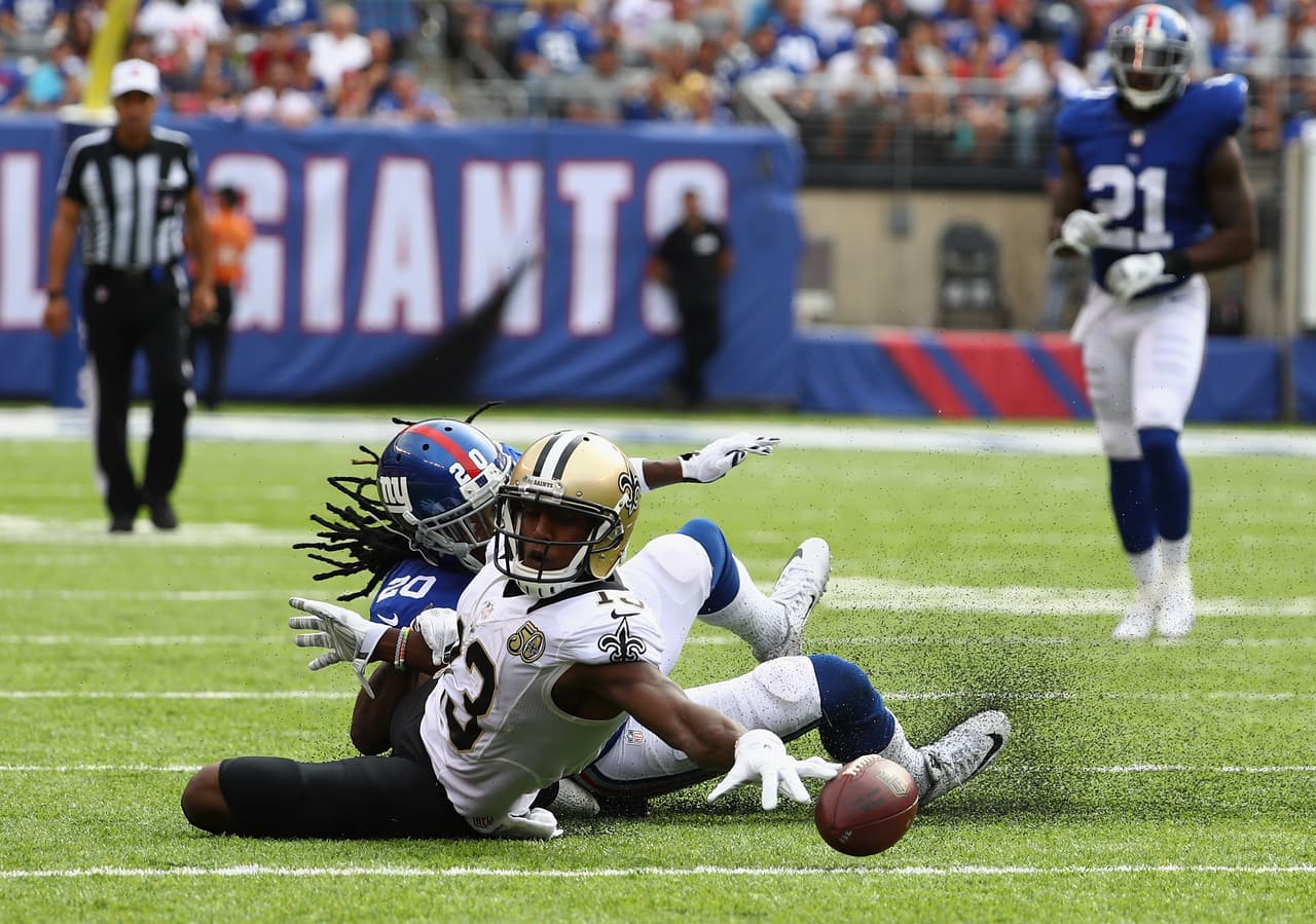 Michael Thomas #13 de los New Orleans Saints tratando de alcanzar la bola ante la presión de Janoris Jenkins #20 de los New York Giants.