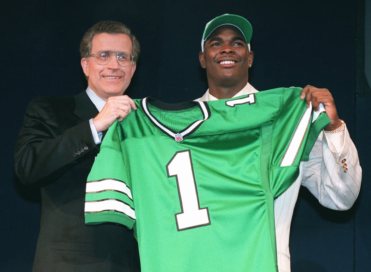 1996 KEYSHAWN JOHNSON | WR Southern Cal - 
<b>New York Jets</b>
<br>
<br>El receptor abierto Keyshawn Johnson de la Universidad del Sur de California, posa con el jersey de los Jets con el comisionado de la NFL, Paul Tagliabue, después de ser tomado por los New York Jets como la primera selección en el draft el sábado 20 de abril de 1996 en Nueva York.