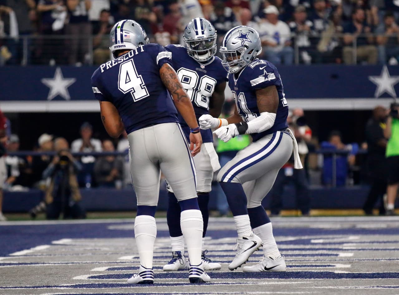 Dallas Cowboys quarterback Dak Prescott (4), wide receiver Dez Bryant (88) and running back Ezekiel Elliott, right, celebrate after Elliott scored a touchdown on a running play in an NFL football game against the Washington Redskins on Thursday, Nov. 24, 2016, in Arlington, Texas. (AP Photo/Roger Steinman)