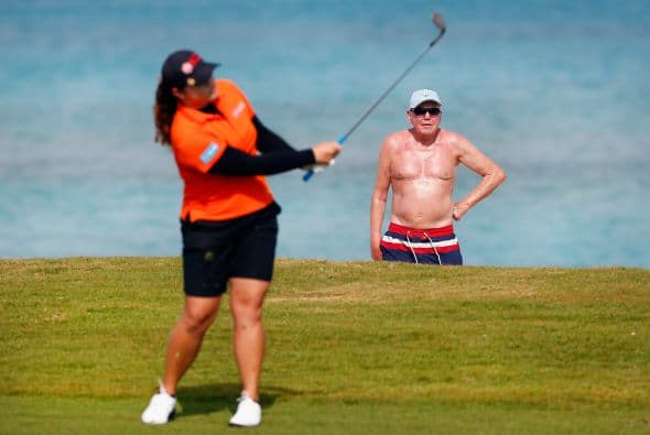 Paradise Island, Bahamas - 05 de febrero: Un bañista observa mientras Ariya Jutanugarn de Tailandia realiza un tiro en el octavo hoyo durante la primera ronda del Pure Silk Bahamas LPGA Classic en el Ocean Club.