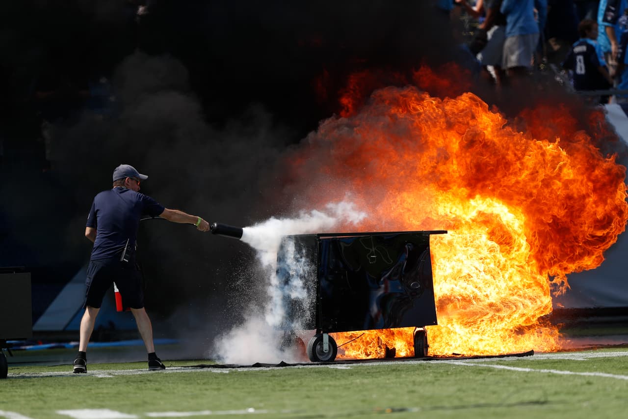 A fire from a pyrotechnics machine is extinguished before an NFL football game between the Tennessee Titans and the Indianapolis Colts Sunday, Sept. 15, 2019, in Nashville, Tenn. (AP Photo/Wade Payne)