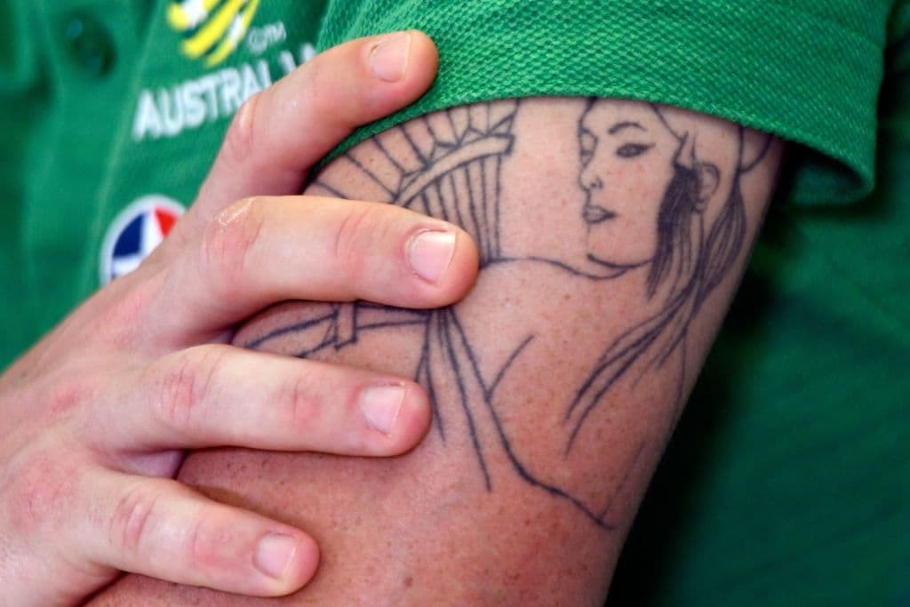 El australiano Mark Gilligan tiene una mujer en su brazo izquierdo y la dejó ver durante su participación en el grupo C.