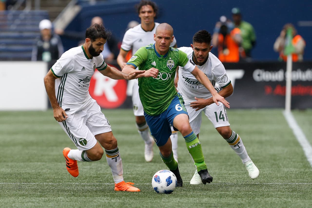 Jun 30, 2018; Seattle, WA, USA; Portland Timbers midfielder Diego Valeri (left) and midfielder Andres Flores (14) double team Seattle Sounders FC midfielder Osvaldo Alonso (6) during the second half at CenturyLink Field. Mandatory Credit: Jennifer Buchanan-USA TODAY Sports