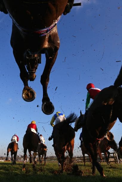 Bangor, Gales - 06 de febrero: Caballos y jinetes saltan una valla durante el Betfair Price Rush Handicap Steeple Chase en las Carreras de Bangor-on-Dee.