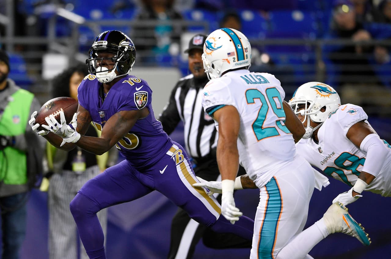 Baltimore Ravens wide receiver Jeremy Maclin, left, catches a pass as he runs for a touchdown in front of Miami Dolphins strong safety Nate Allen (29) and cornerback Bobby McCain in the first half of an NFL football game, Thursday, Oct. 26, 2017, in Baltimore. (AP Photo/Nick Wass)