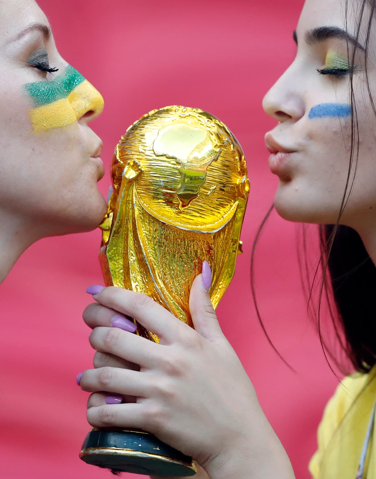 Brazil's supporters pose with a model of the World Cup trophy as they wait for the start of the quarterfinal match between Brazil and Belgium at the 2018 soccer World Cup in the Kazan Arena, in Kazan, Russia, Friday, July 6, 2018. (AP Photo/Frank Augstein)