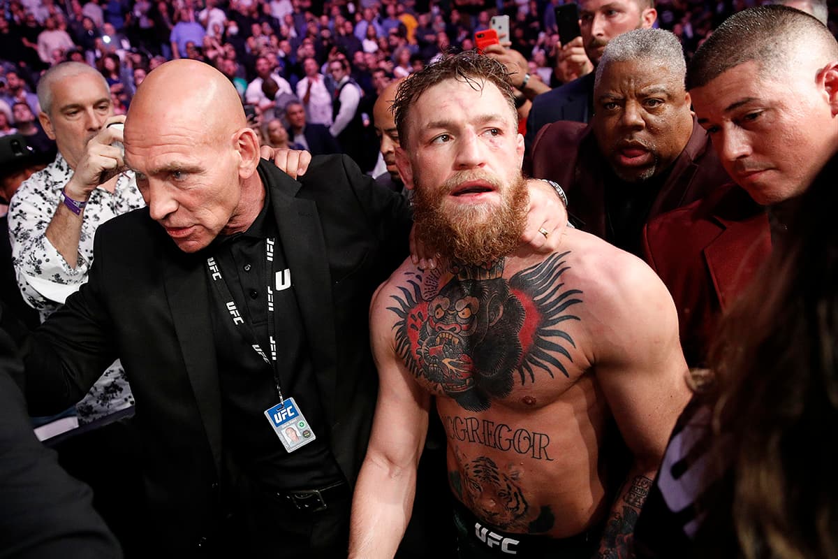 Después de perder por rendición, Conor McGregor (centro) fue atacado por la espalda por ayudantes de Khabib Nurmagomedov y al final se retiró por su propia cuenta del T-Mobile Arena de Las Vegas.