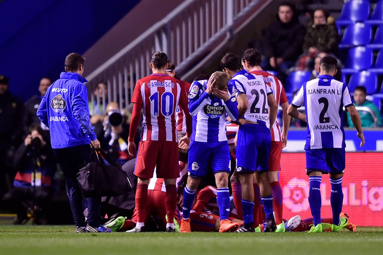 Atletico Madrid's forward Fernando Torres (on the ground) is helped by teammates after colliding with Deportivo La Coruna's midfielder Alex Bergantinos during the Spanish league football match RC Deportivo de la Coruna vs Club Atletico de Madrid at the Municipal de Riazor stadium in La Coruna on March 2, 2017. The match ended with a 1-1 draw. / AFP PHOTO / MIGUEL RIOPA (Photo credit should read MIGUEL RIOPA/AFP/Getty Images)