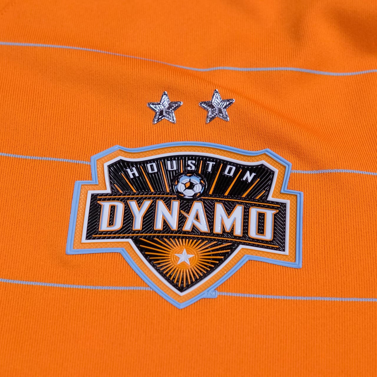 Houston Dynamo no varía demasiado en el diseño de su camiseta titular, con la excepción del agregado de finas rayas en color celeste a lo ancho del uniforme. (Crédito: Houston Dynamo)