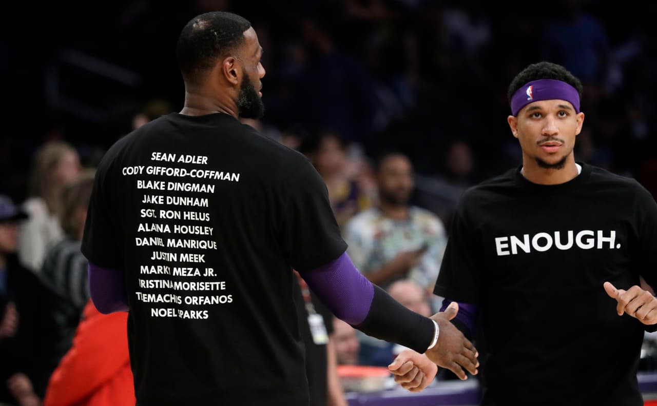 Los Angeles Lakers' LeBron James, left, and Josh Hart wear t-shirts bearing the names of the 12 victims of Wednesday night's shooting at a bar in Thousand Oaks, Calif., before an NBA basketball game against the Atlanta Hawks Sunday, Nov. 11, 2018, in Los Angeles. (AP Photo/Marcio Jose Sanchez)