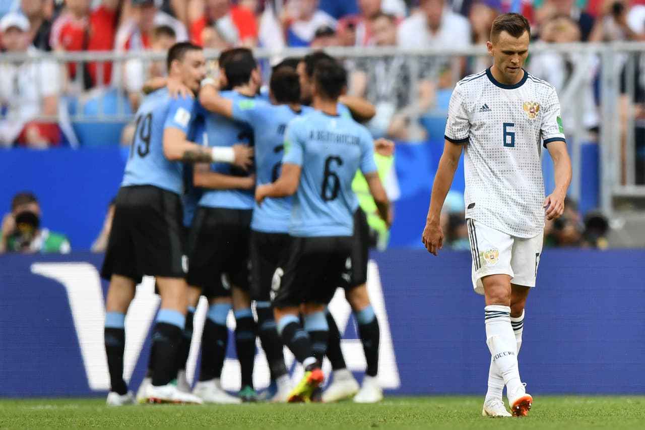 TOPSHOT - Russia's midfielder Denis Cheryshev reacts as Uruguay celebrate their second goal during the Russia 2018 World Cup Group A football match between Uruguay and Russia at the Samara Arena in Samara on June 25, 2018. (Photo by Fabrice COFFRINI / AFP) / RESTRICTED TO EDITORIAL USE - NO MOBILE PUSH ALERTS/DOWNLOADS (Photo credit should read FABRICE COFFRINI/AFP/Getty Images)