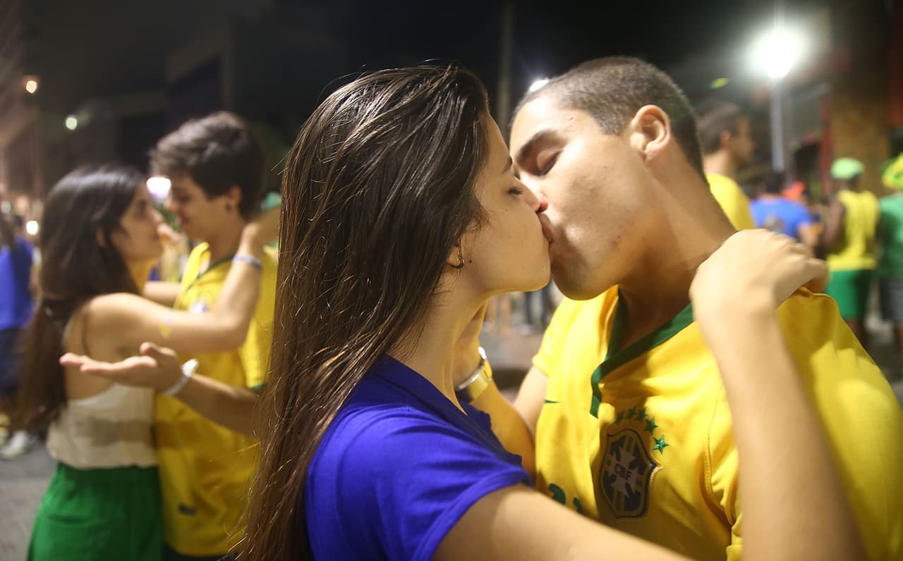 SALVADOR, BRAZIL - JUNE 17: Brazil fans kiss after watching the Brazil-Mexico match in the 2014 FIFA World Cup on June 17, 2014 in Salvador, Brazil. Today is the sixth day of the World Cup and the second match for home team Brazil. (Photo by Mario Tama/Getty Images)