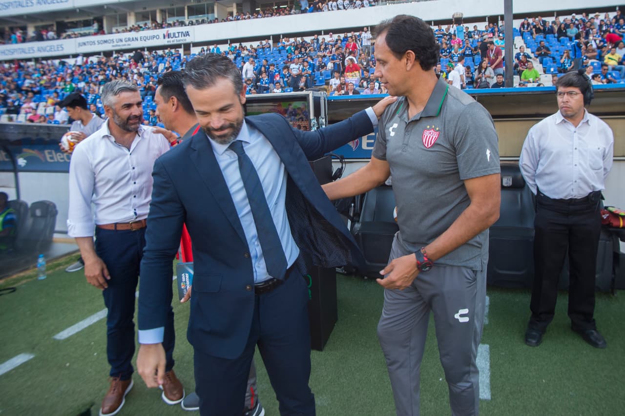 Rafael Puente y Martín Salcedo, asistente de la dirección técnica de Necaxa, en un cordial saludo antes del silbatazo inicial.