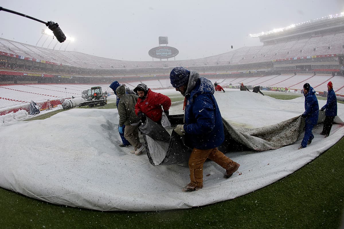 Los asistentes de campo retiraron la cubierta con gran cantidad de nieve en Arrowhead Stadium.