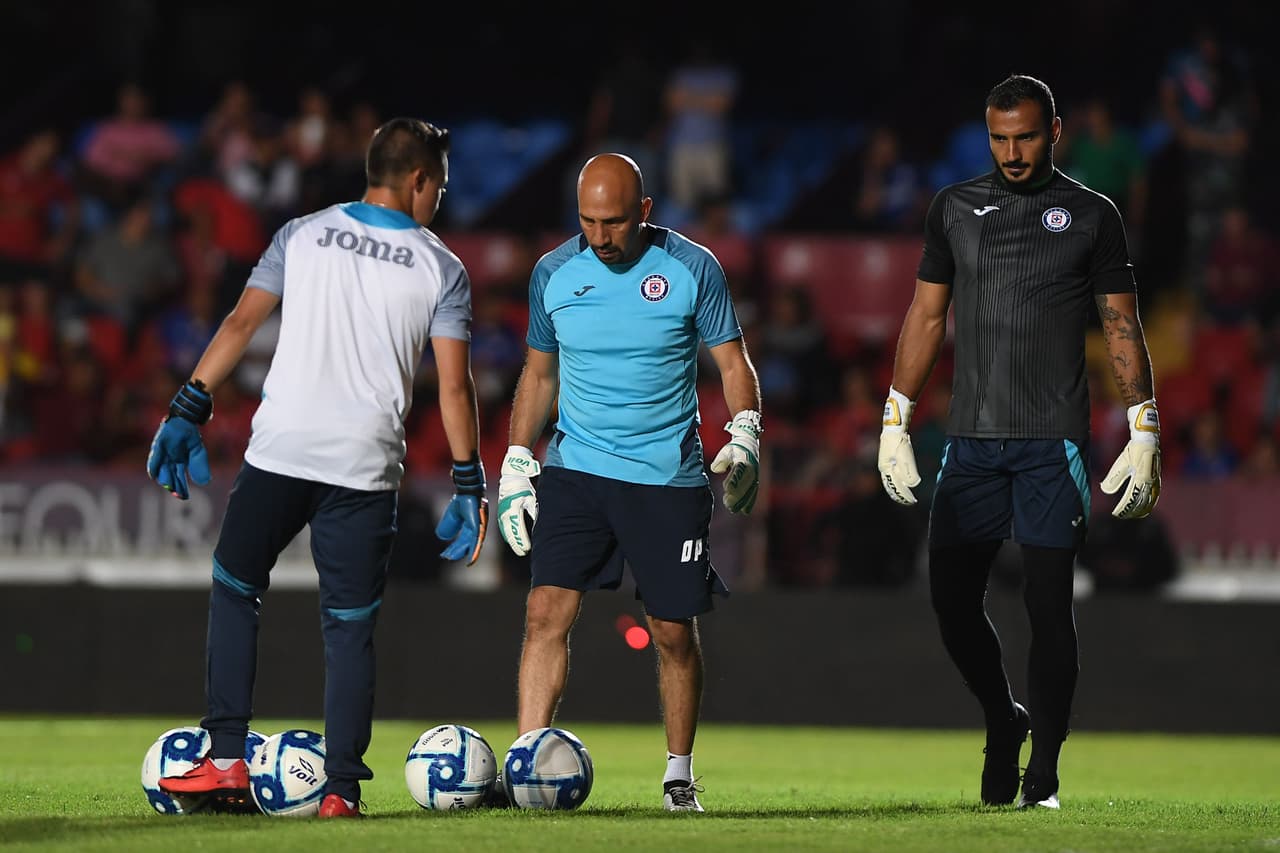 Óscar 'el Conejo' Pérez, entrenador de porteros, calienta con Chuy Corona y los arqueros del Cruz Azul.