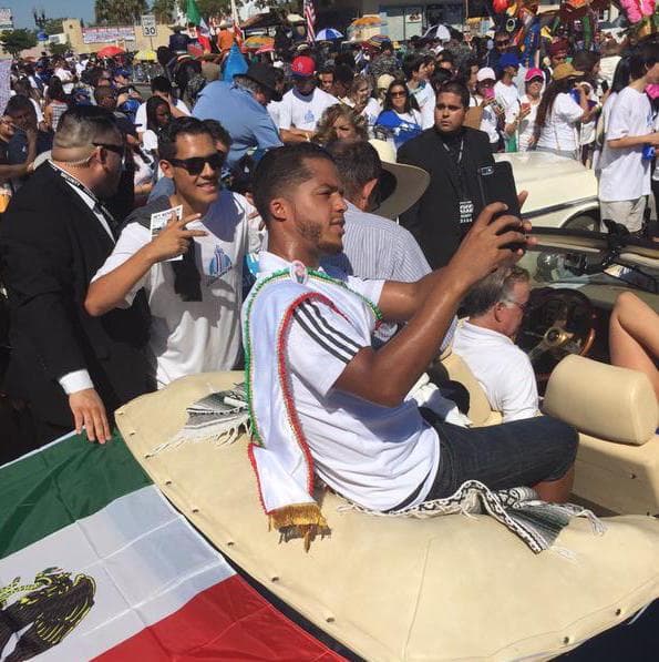 El jugador de LA Galaxy y el Tri no quiso perderse la oportunidad de retratar el momento en en su teléfono móvil mientras lo paseaban por East Los Angeles en un convertible.