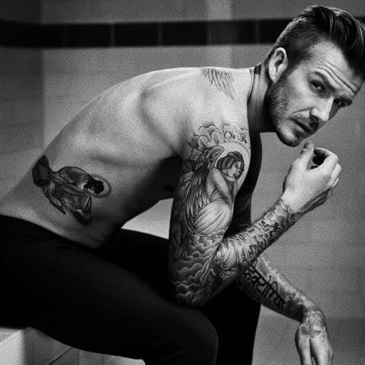 Destacan el Cristo en su costado derecho, el ángel en su brazo, el nombre de su pareja en la mano derecha y el ángel en su espalda con los nombres de sus hijos.