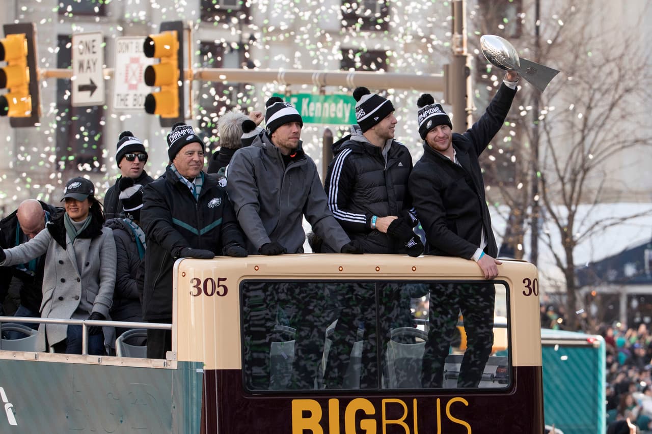 Jeffrey Lurie, dueño del equipo, Nick Foles, Nate Sudfeld y Carson Wentz, quien sostiene el trofeo.