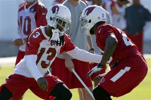 Jaron Brown (#13) tratando de supercar la marca del safety Chris Clemons (#29) (AP-NFL).
