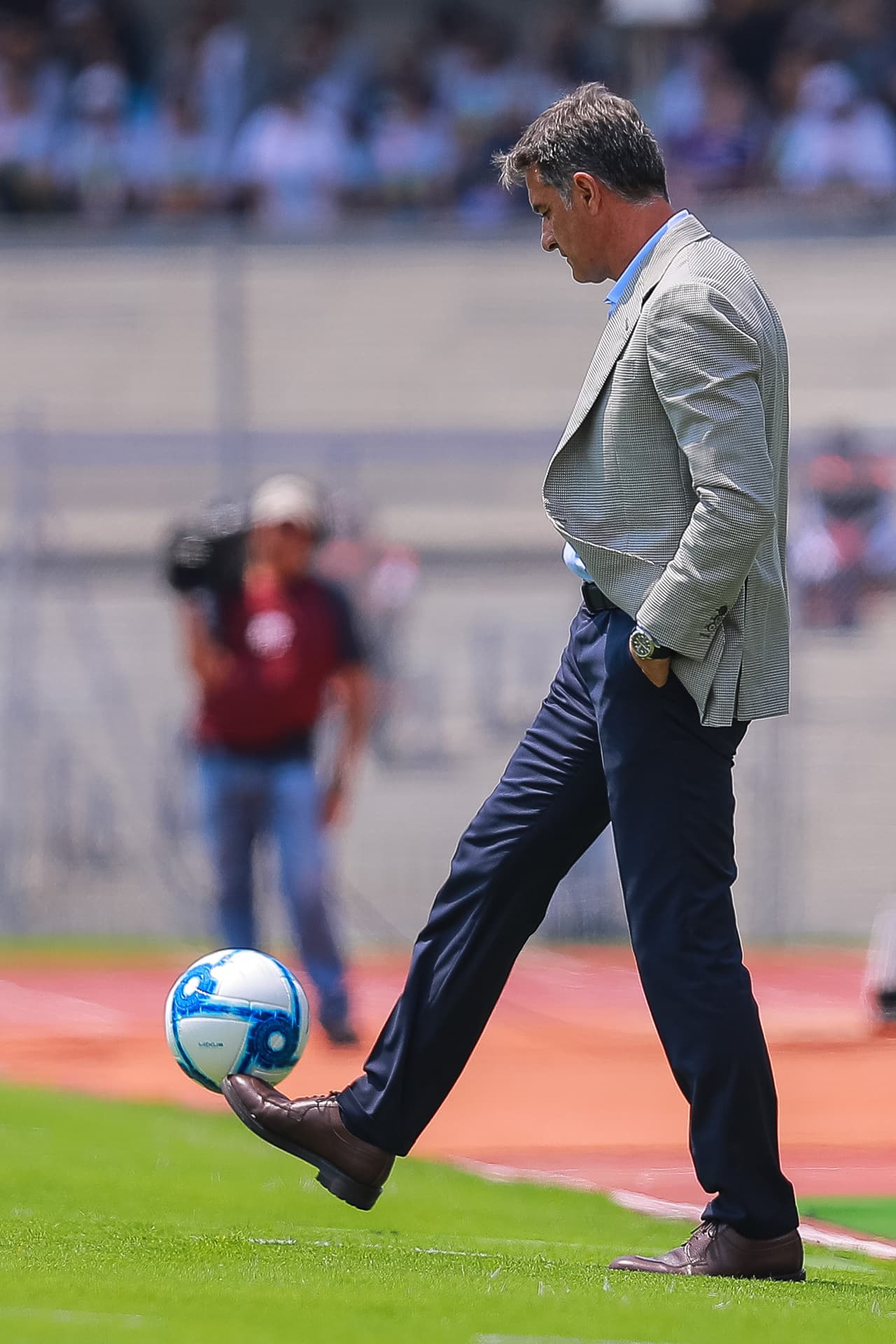 Sin importar la elegancia, 'Michel', esratega de Pumas muestra su técnica a pesar de usar traje.