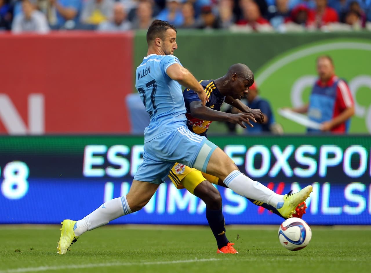 Bradley Wright Phillips encuentra un mínimo espacio para rematar ante la marca de RJ Allen.