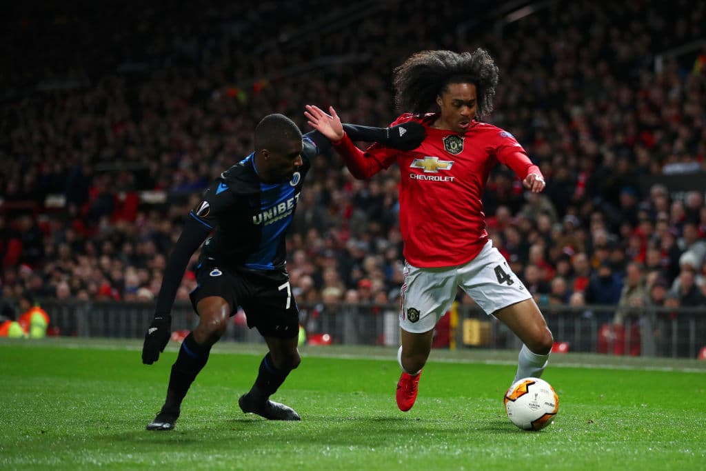 Tahith Chong, del Manchester United, pelea hombro a hombro con Clinton Mata, del Brugge, por el esférico sin que el rival se lo pueda quitar.