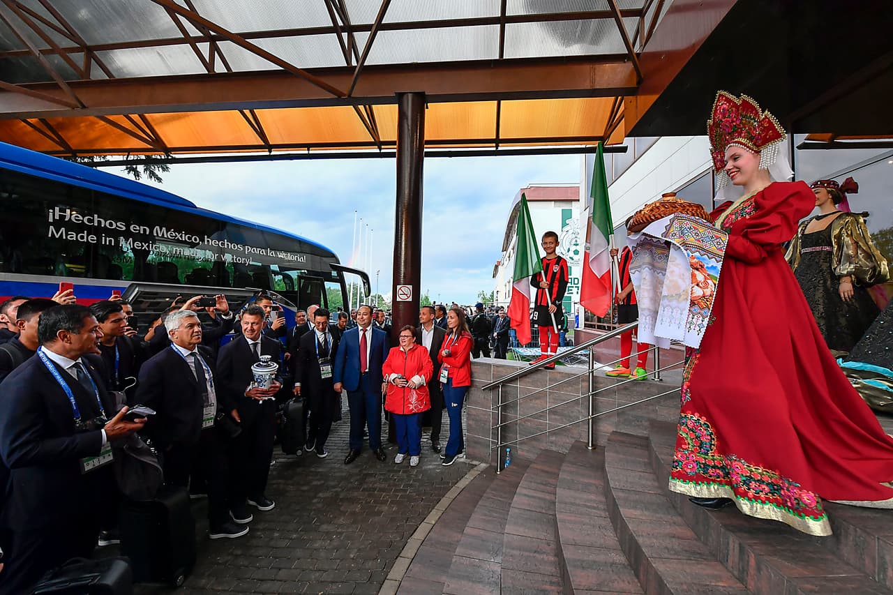 Al fondo de la imagen se observa la bandera mexicana, y en primer plano, una de las mujeres de la comitiva de bienvenida para el Tri, con un traje a la usanza moscovita. (Foto: IMAGO7)