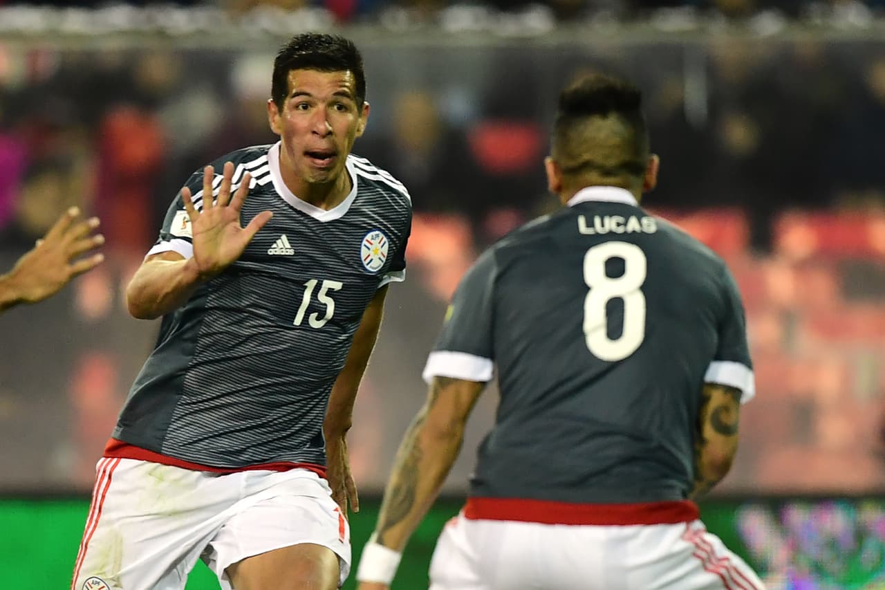 Paraguay's Victor Caceres (L) celebrates with teammate Lucas Barrios after scoring against Chile during their 2018 World Cup qualifier football match, in Santiago, on August 31, 2017. / AFP PHOTO / Martin BERNETTI (Photo credit should read MARTIN BERNETTI/AFP/Getty Images)