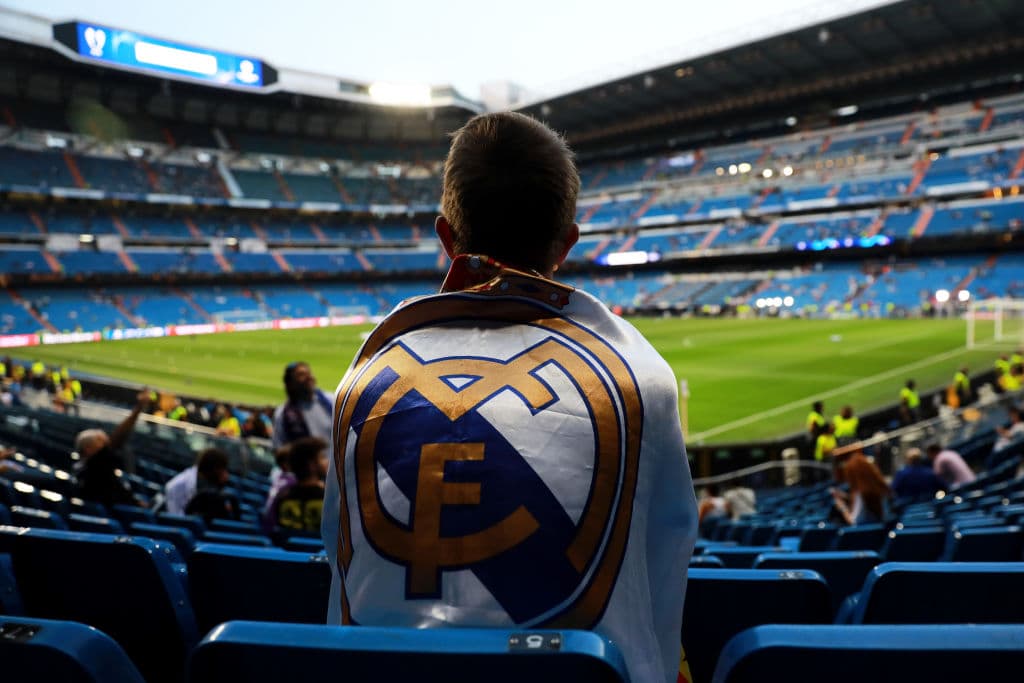 La espera, el nervio y las ansias no son diferentes en otras partes del continente. En el Santiago Bernabéu este joven también, envuelto en la bandera del Real Madrid, aguarda por los Merengues.